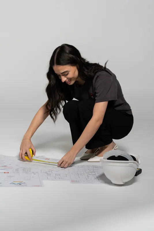 Sydney Drafting designer measuring drawings on the floor with a tape measure