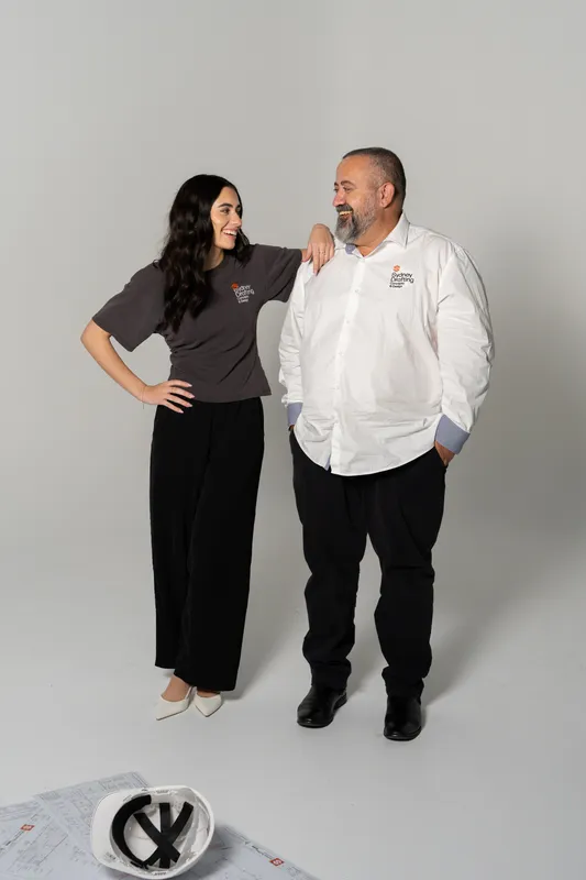 Two Sydney Drafting directors standing side by side on a white studio backdrop