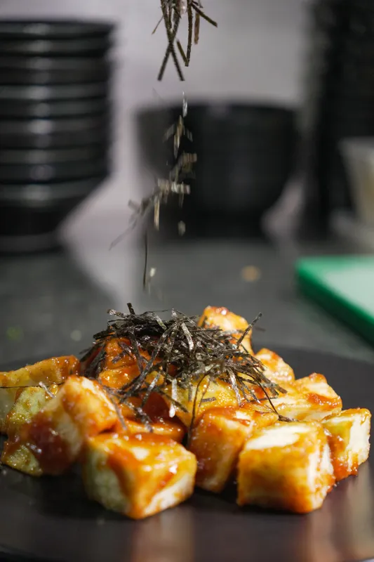 Seaweed falling onto glazed agedashi tofu at Aji Japanese Cuisine