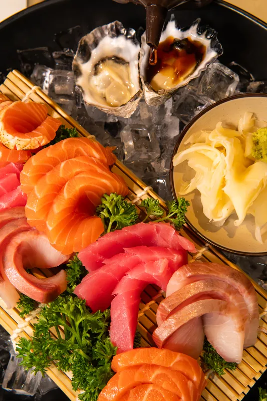 Sashimi platter of salmon, tuna and kingfish with oysters and pickled ginger on ice at Aji Japanese Cuisine