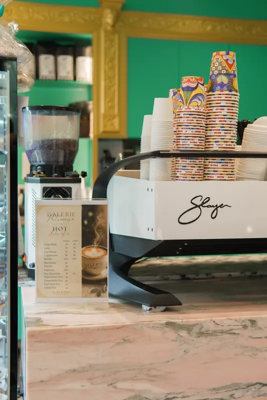 Coffee machine and stacked takeaway cups at the Galerie Pâtisserie counter