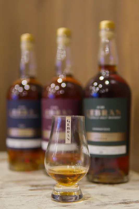 Three bottles of aged spirit and a tasting glass at Gebran Lebanese Cuisine