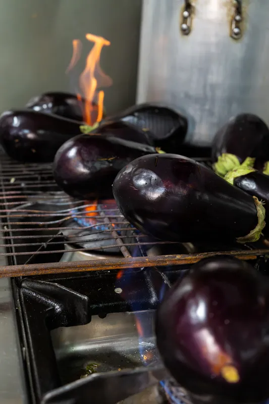 Eggplants charring over open gas flames in the kitchen at Gebran Lebanese Cuisine