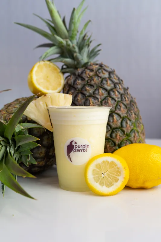 Purple Parrot pineapple smoothie with a whole pineapple and lemons