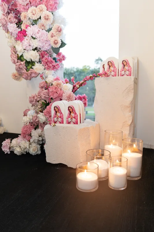 Holy Communion styling: pink and white flowers, pillar candles and a white plinth