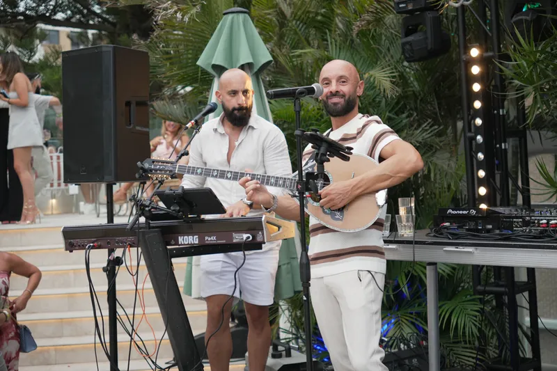 Live band of a keyboardist and an oud player performing at an outdoor party